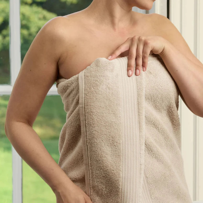 Person wrapped in a CHRISTY Supreme Hygro Towels - Stone