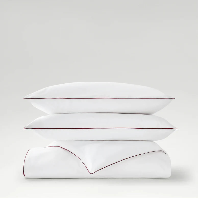 Two white pillows with red stitching on a light gray background