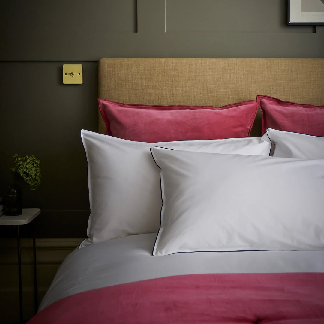 Bed with red and white bedding against a dark wall
